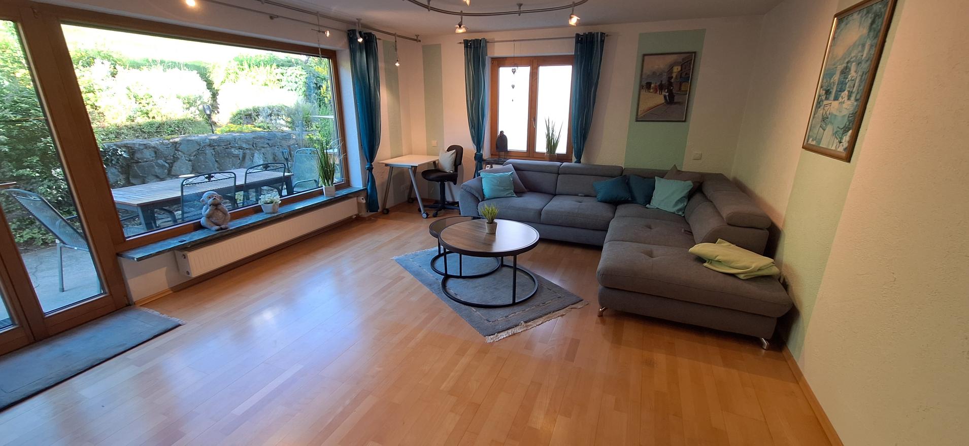 Helles Wohnzimmer mit großem Fenster zum Garten